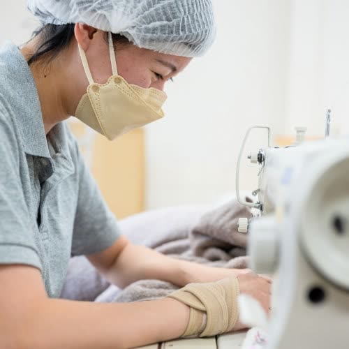 ミシンに向かう若手スタッフ